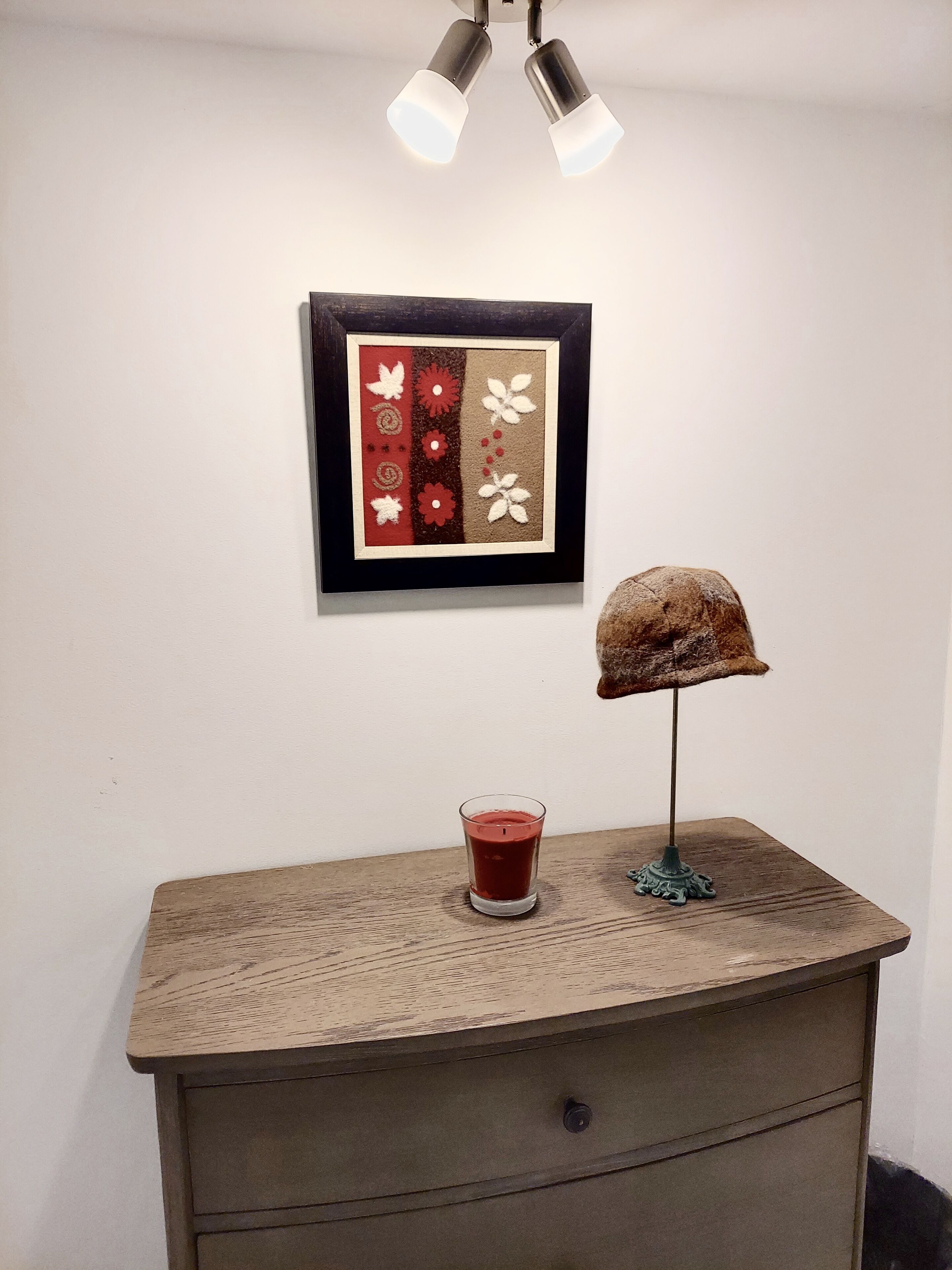 Un aparador de madera con un candelabro de vidrio y una lámpara decorativa.