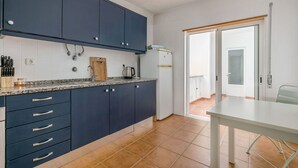A kitchen with dark blue cabinets, a white countertop, and a white table. - Sweet 2-Bedroom Townhouse (Lagos)