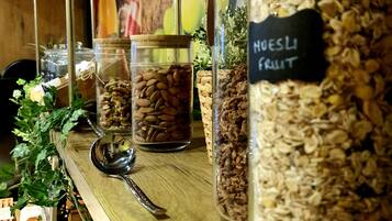 Een houten plank met diverse potten gevuld met noten, zaden en granen.