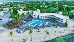 Un resort con una piscina grande, zona de playa y varias edificaciones.
