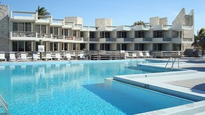 Una piscina con varios niveles de asientos y un edificio de fachada de piedra al fondo.