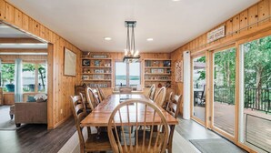 Ein Holzinterieur mit einem Esstisch, Stühlen und Blick ins Freie.