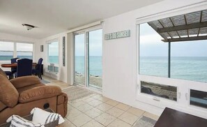 Enjoy the breathtaking sea view from this cozy living area with a large window and comfortable seating.