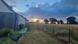 Un paysage rural avec une grange, une maison et un champ.