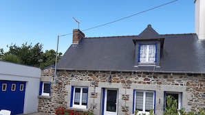 A stone house with a grey roof, blue shutters, and a small window with a white frame. - Maison Bord de mer avec Jardin clos 3 CH/7 Personnes Plage à 550m (HILLION)