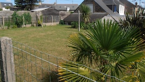 A residential area with houses, a fenced yard, and a palm tree. - Maison Bord de mer avec Jardin clos 3 CH/7 Personnes Plage à 550m (HILLION)