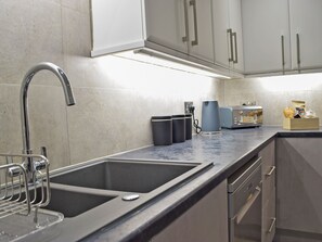 A modern kitchen with stainless steel appliances, a double sink, and a countertop with a toaster and coffee maker. - 5 bedroom accommodation in New Quay (New Quay)
