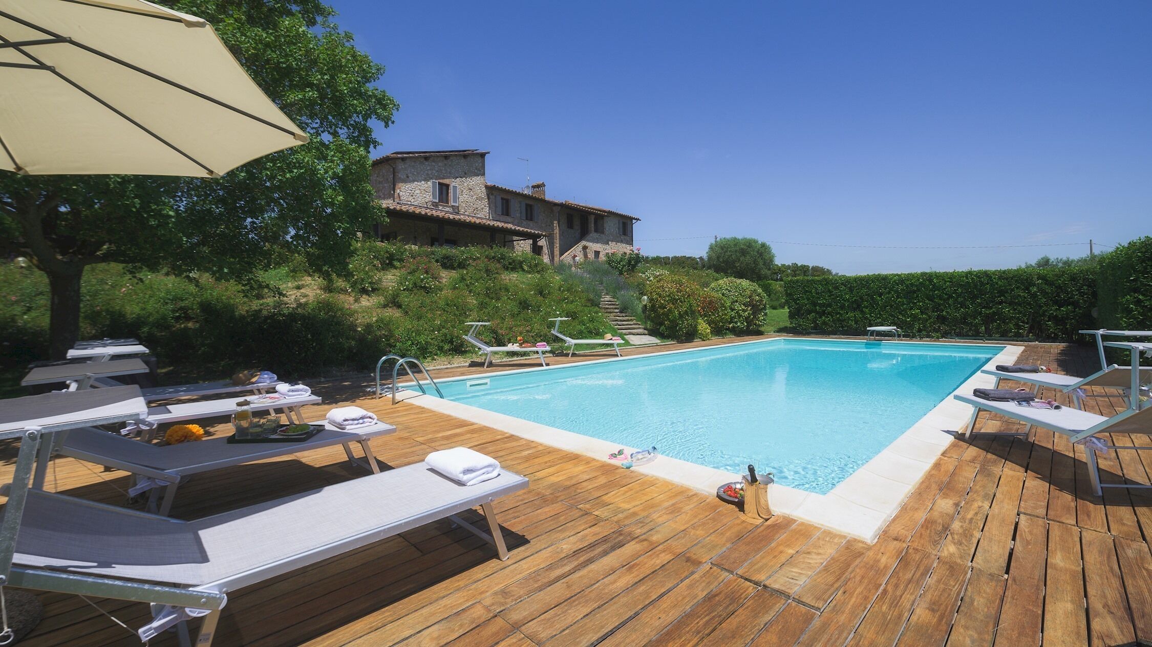 A wooden deck with lounge chairs and a swimming pool.