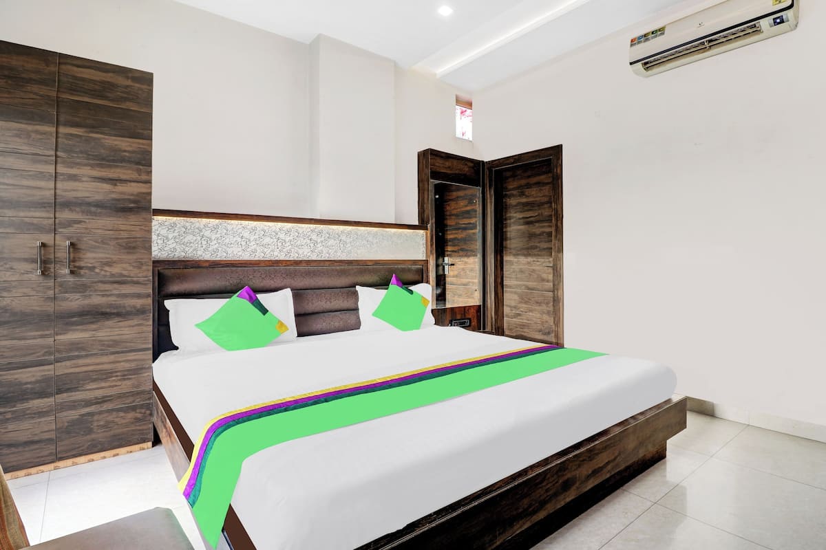 Un dormitorio moderno con una cama grande, un armario de madera y una ventana pequeña.