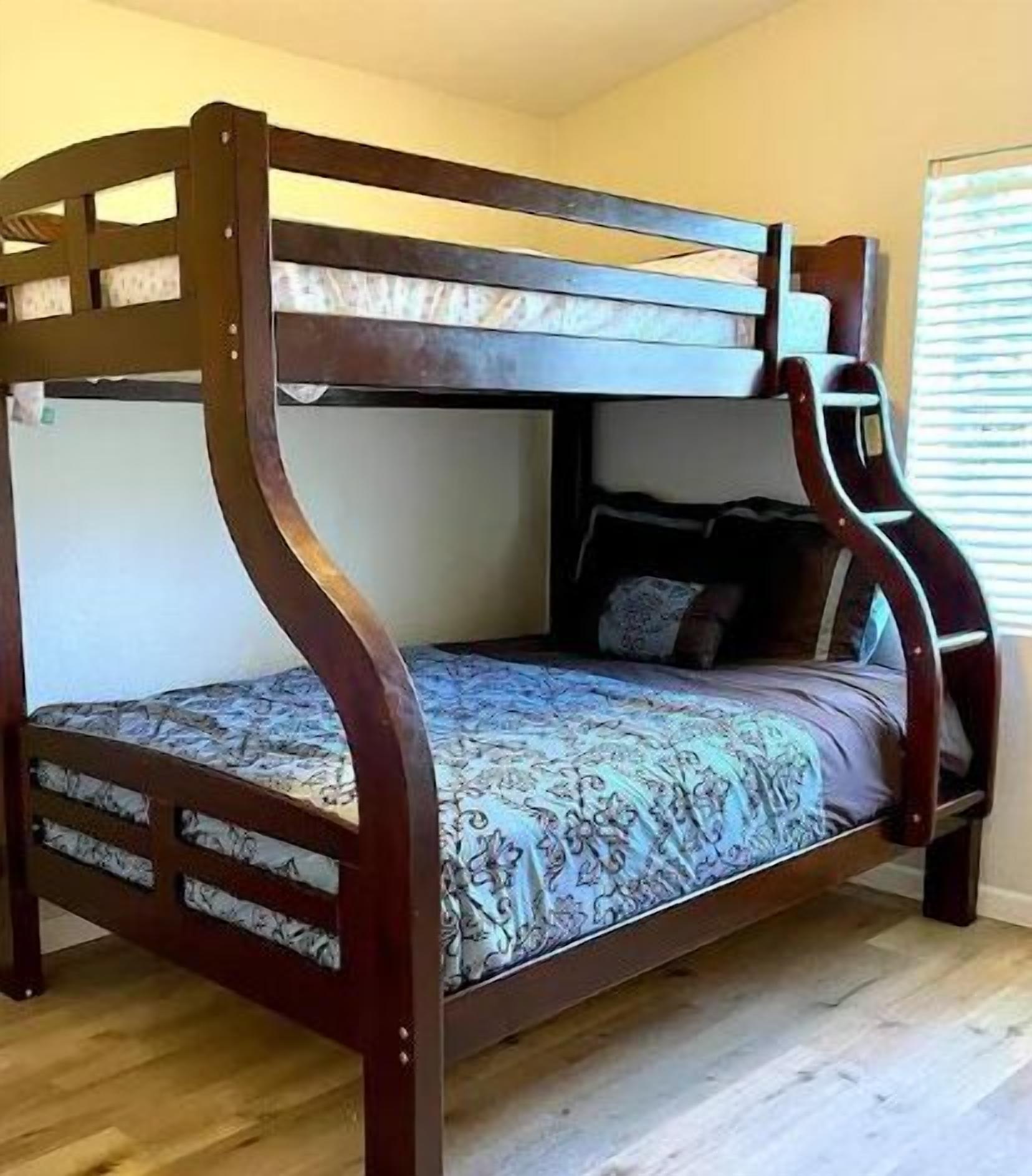 Een stapelbed met een houten frame en beddengoed met een patroon.