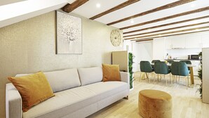 Una sala moderna con sofá, reposapiés y comedor con sillas.