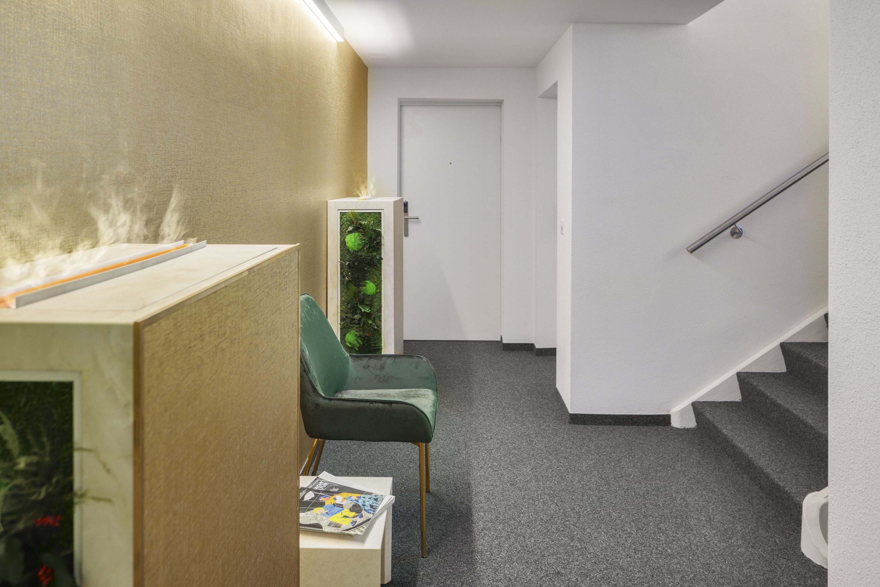 Um espaço de escritório moderno com uma cadeira verde, uma pequena mesa com papéis e uma escada.