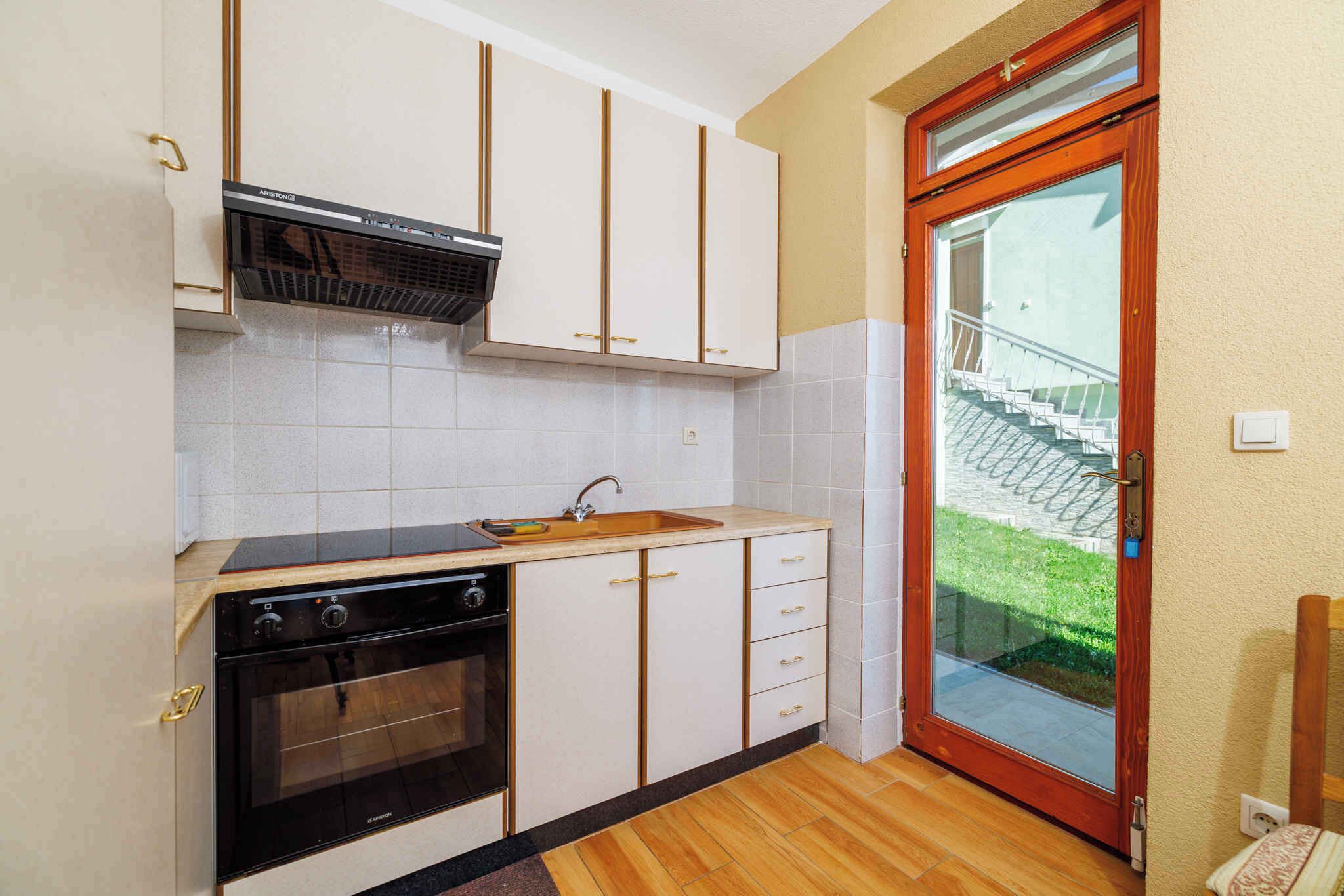 Une cuisine avec des armoires blanches, une cuisinière noire et un plan de travail en bois.