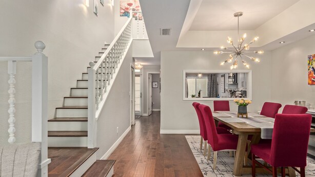 Un interior moderno con escalera, comedor y cocina.