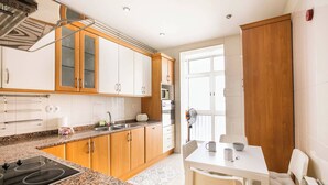 Una cocina moderna con encimeras de granito, armarios de madera y estufa empotrada.