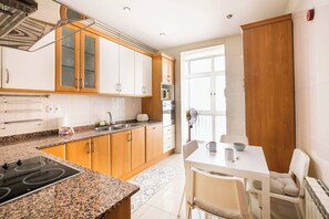 A modern kitchen with granite countertops, wooden cabinets, and a built-in stove.