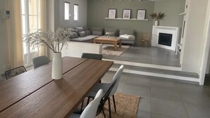 Un soggiorno moderno con divano, tavolo da pranzo e camino.