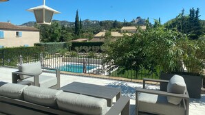 Una terrazza sul tetto con piscina, area relax all'aperto e vista su un paesaggio montuoso.
