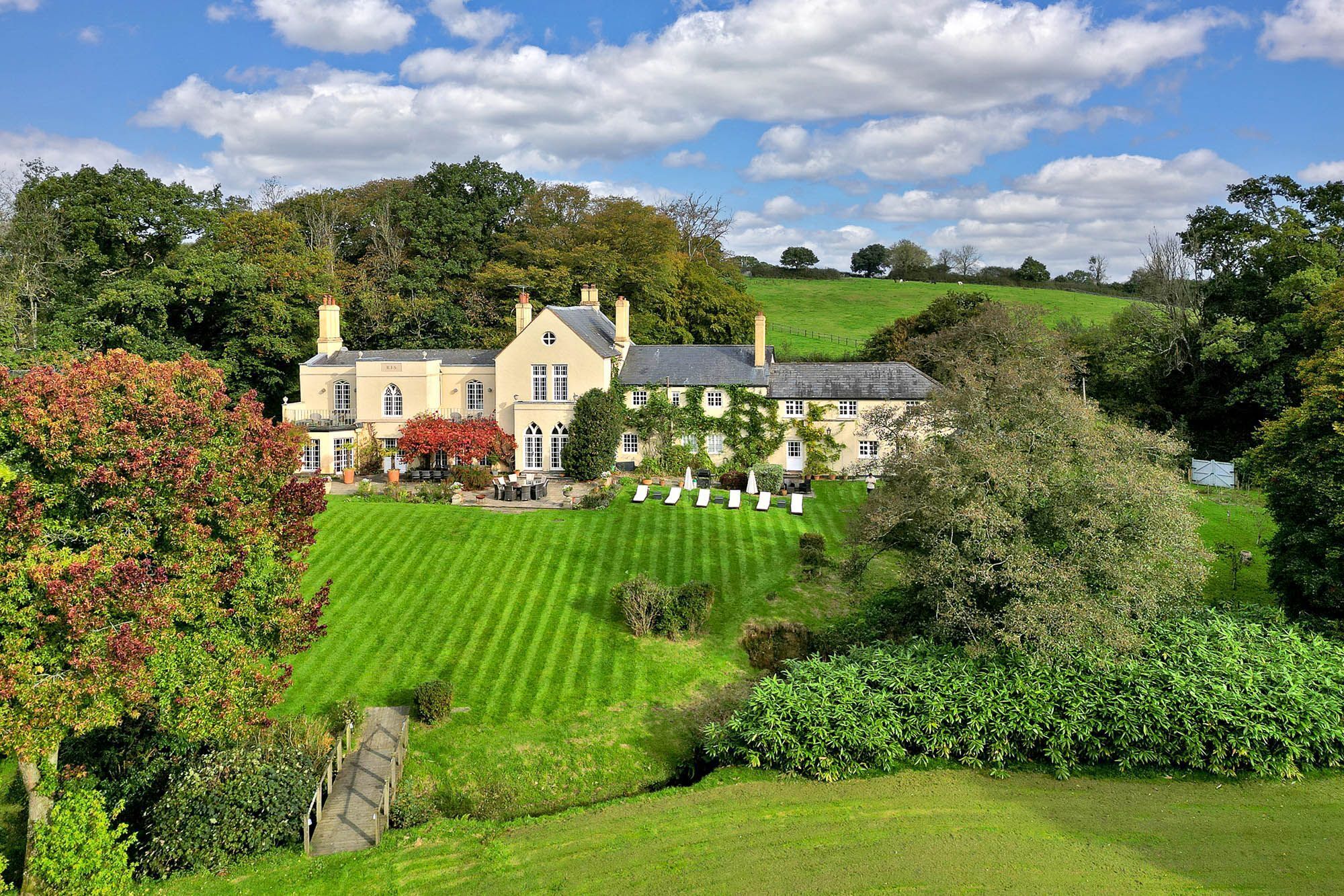 A large, multi-story building with a well-maintained lawn and garden in front.