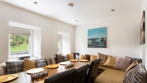 Un comedor con una mesa de madera dispuesta para cuatro personas, rodeada por un sofá y sillas.