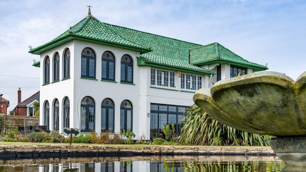 A traditional building with a green roof and arched windows, reflecting in a calm water body in front. - Culver Down Manor - Seven Bedroom Villa, Sleeps 16 (Shanklin)