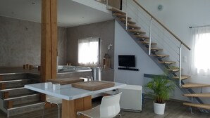 Un espace de vie moderne comprenant une cuisine, un coin repas et un escalier.