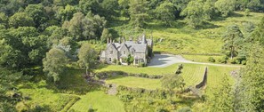 A large stone manor surrounded by lush greenery and a winding driveway. - Tarbert Country Manor (Tarbert)