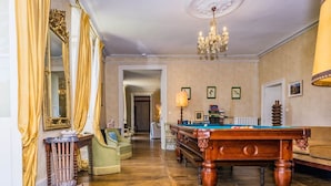 Una habitació àmplia amb billar, un mirall gran i un penjador.