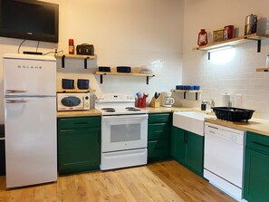 Enjoy cooking and preparing meals in this well-equipped kitchen with a refrigerator, oven, and dishwasher.