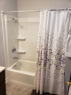 Bañera con ducha, secador de pelo, toallas, jabón