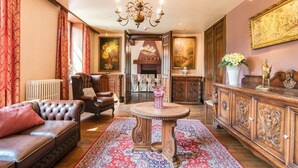 Une pièce de style traditionnel, dot ée d’une cheminée, d’un canapé en cuir, d’une table à manger et d’un buffet.