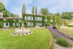 A large, ivy-covered building with multiple windows and a central circular fountain. - The Millhouse - Ten Bedroom Villa, Sleeps 24 (Annepont)
