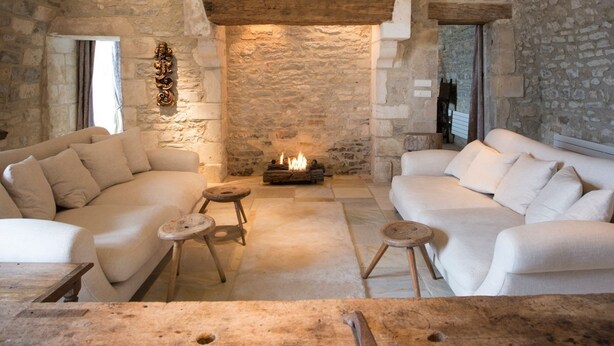 A cozy room with a stone fireplace, two sofas, and a small wooden table.