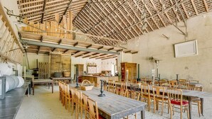 A spacious hall with multiple wooden tables and chairs, a high ceiling with exposed beams, and a rustic aesthetic. - The Secret Hamlet - Eleven Bedroom Castle, Sleeps 24 (Ingrandes)