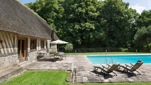 A thatched-roof building with a stone exterior, a swimming pool, and a grassy lawn. - Domaine Du Pont - Chateau Only (Saint-Maclou)