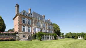 A large, historic building with a symmetrical facade, multiple chimneys, and a well-manicured lawn. - Domaine Du Pont - Chateau Only (Saint-Maclou)
