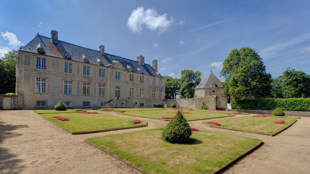 A large, historic stone building with a symmetrical facade, a central tower, and a well-maintained garden with geometric flower beds and hedges. - Chateau Les Douves - Eight Bedroom Castle, Sleeps 14 (Fontenay-sur-Mer)