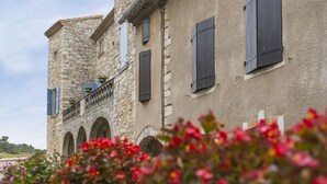 A stone building with arched windows and a balcony.
