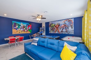 A room with a blue sofa, red chairs, a pool table, and two large wall paintings. - Luxury Villa Storey Lake, 15min→Disney, private pool + hot tub + No Extra Fees (Kissimmee)