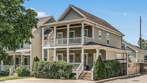 A two-story house with a front porch, a covered front entrance, and a small front yard.