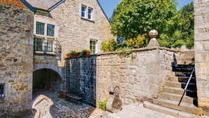 A stone building with a stone staircase and a small balcony.