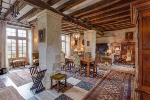 A traditional room with a checkered floor, wooden furniture, and stone pillars.