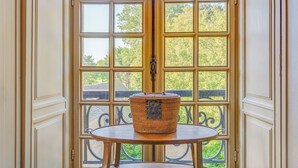Une pièce d’angle avec une grande fenêtre, une table en bois et un panier en osier.
