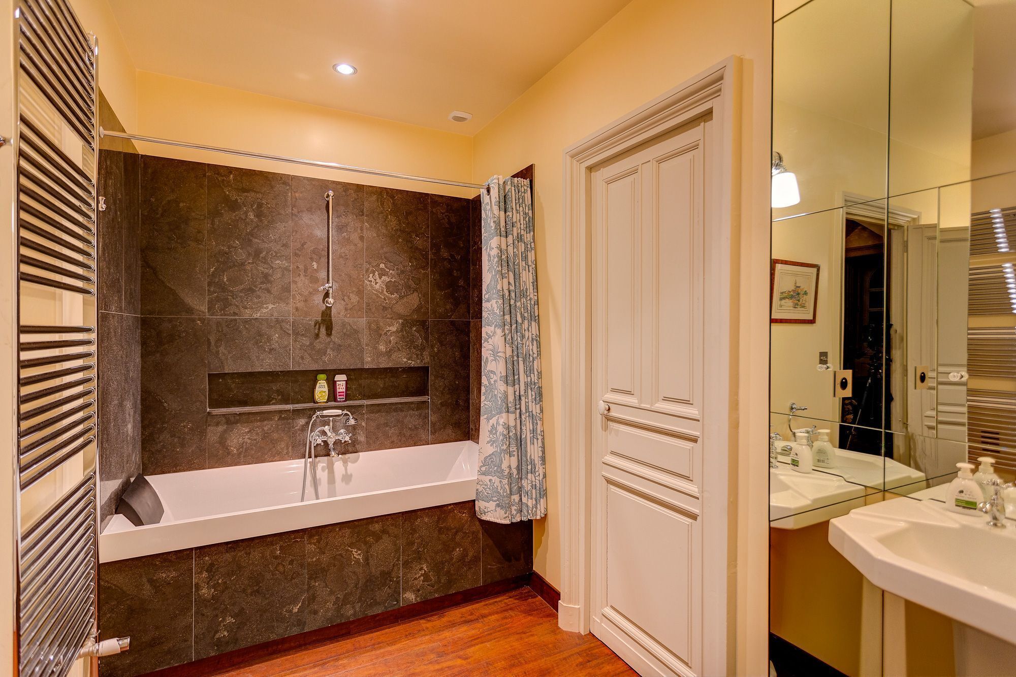 Un baño moderno con bañera, ducha y tocador con espejo.