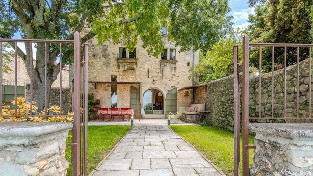 A stone pathway leading to a rustic building with a covered patio area.
