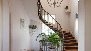 Una escalera con barandilla de madera y pared blanca.