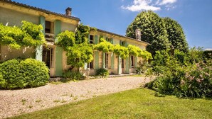 Un bâtiment à deux étages avec une allée en gravier et un jardin bien entretenu.