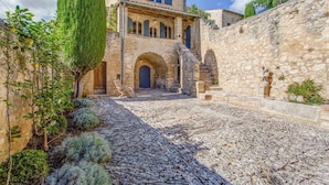 Un edificio de piedra con un patio, arcos y una escalera que conduce a un nivel superior.