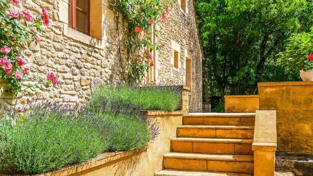 Un bâtiment en pierre avec un escalier menant à une fenêtre.