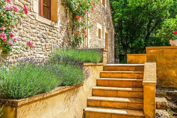 Un edificio de piedra con una escalera que conduce a una ventana.
